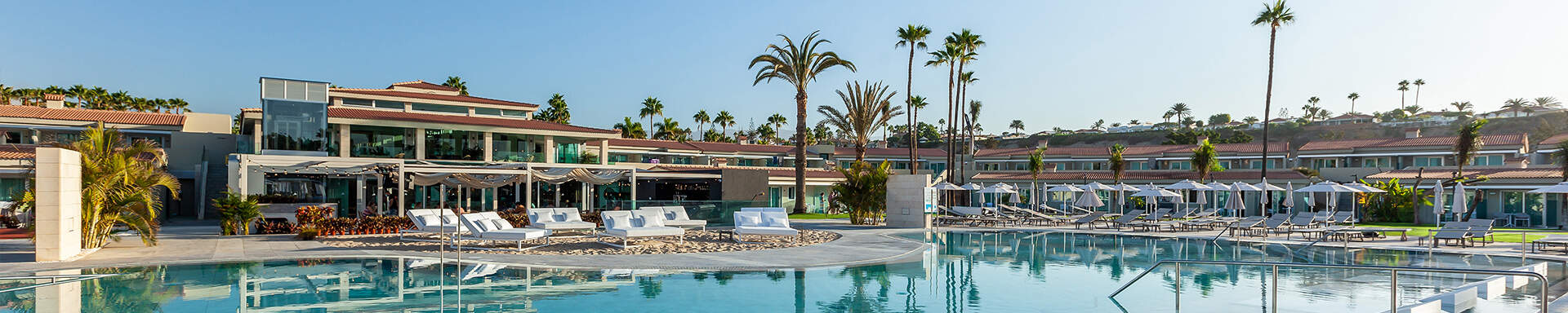 Hotel met ligbedden en paraols aan het zwembad