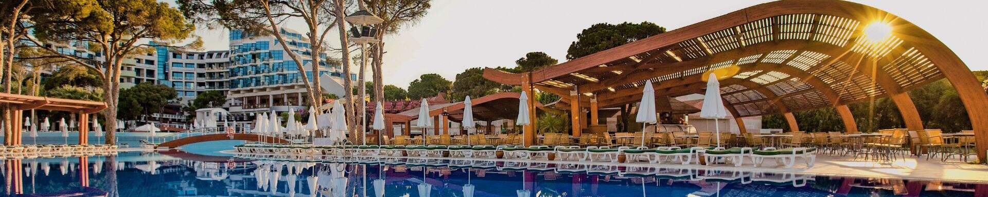 zwembad,witt parasols,zonsondergang,bomen