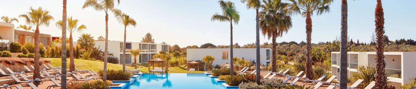 Luxe zwembad van het Tivoli hotel met ligbedjes en palmbomen 