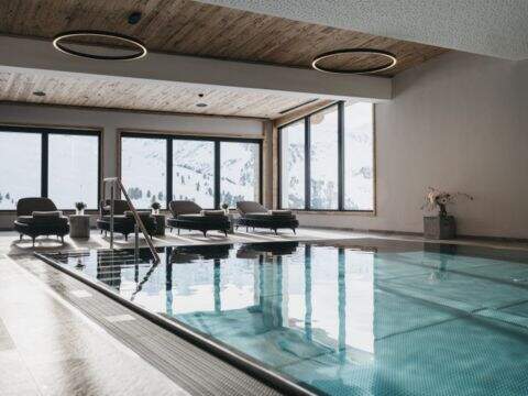 Binnenzwembad, ligbedden, uitzicht op besneeuwde piste