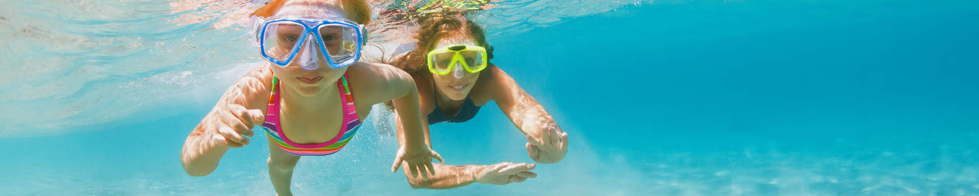 Kinderen met een duikbril aan het zwemmen in de zee 