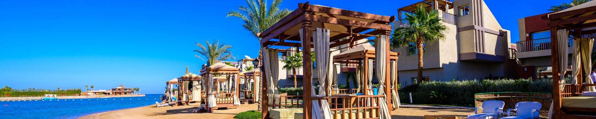 strand in hurghada met palmbomen en strandbedjes