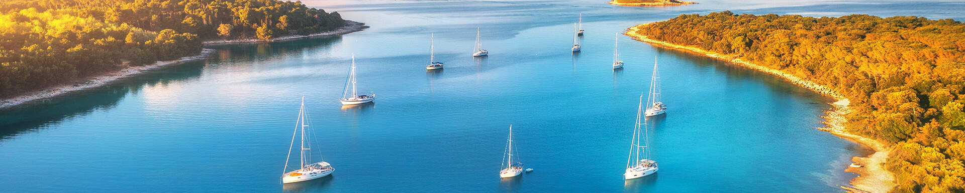 Prachtige baai met meerdere zeilboten in de avondzon