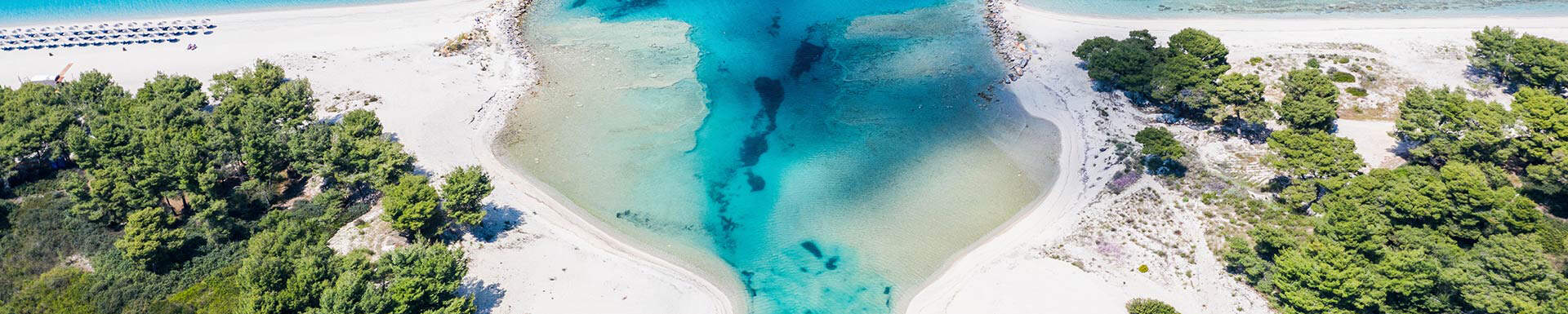 bovenaanzicht van twee eilanden met bomen en een helder blauwe zee