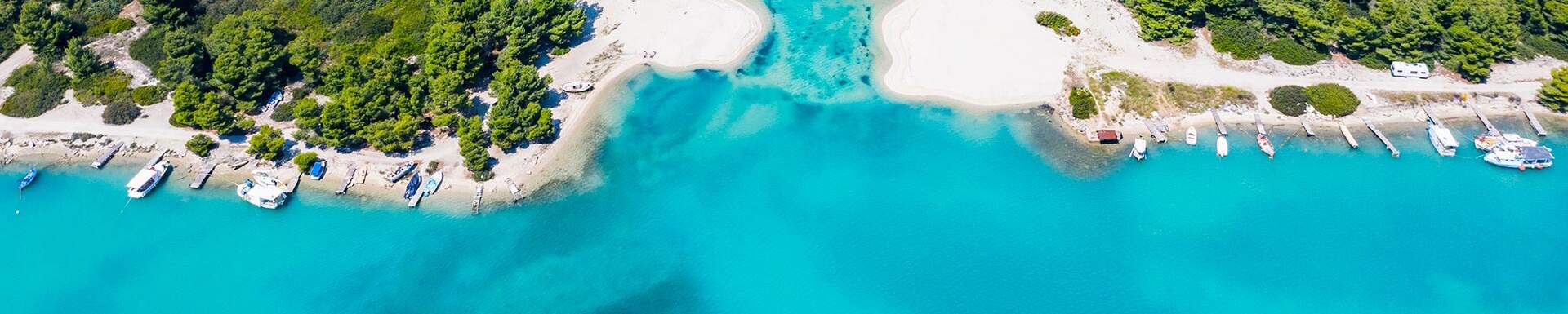 bovenaanzicht van een kust met helder blauw water met de bootjes