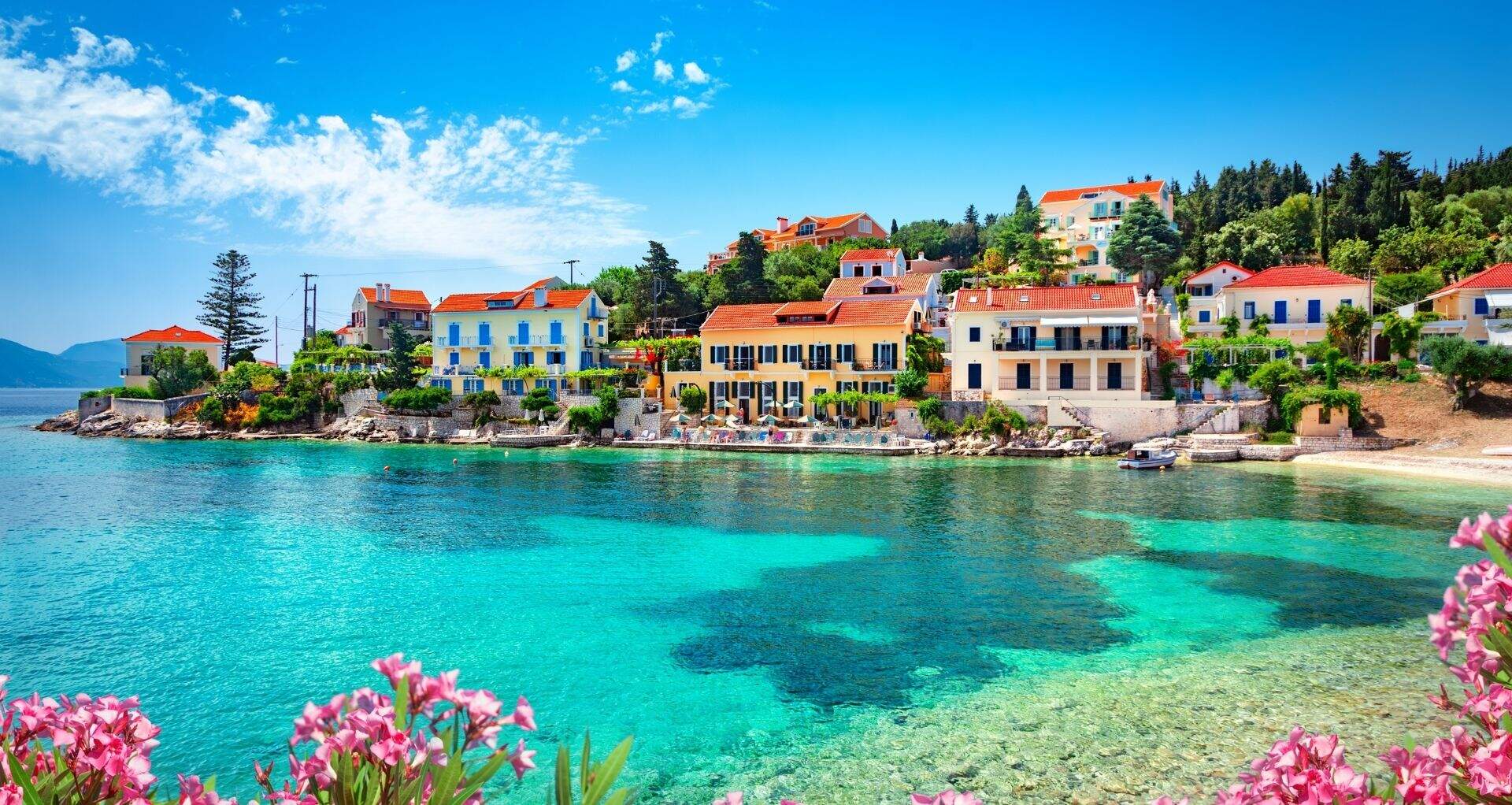 Blauwgroene zee, omringd door gekleurde huisjes