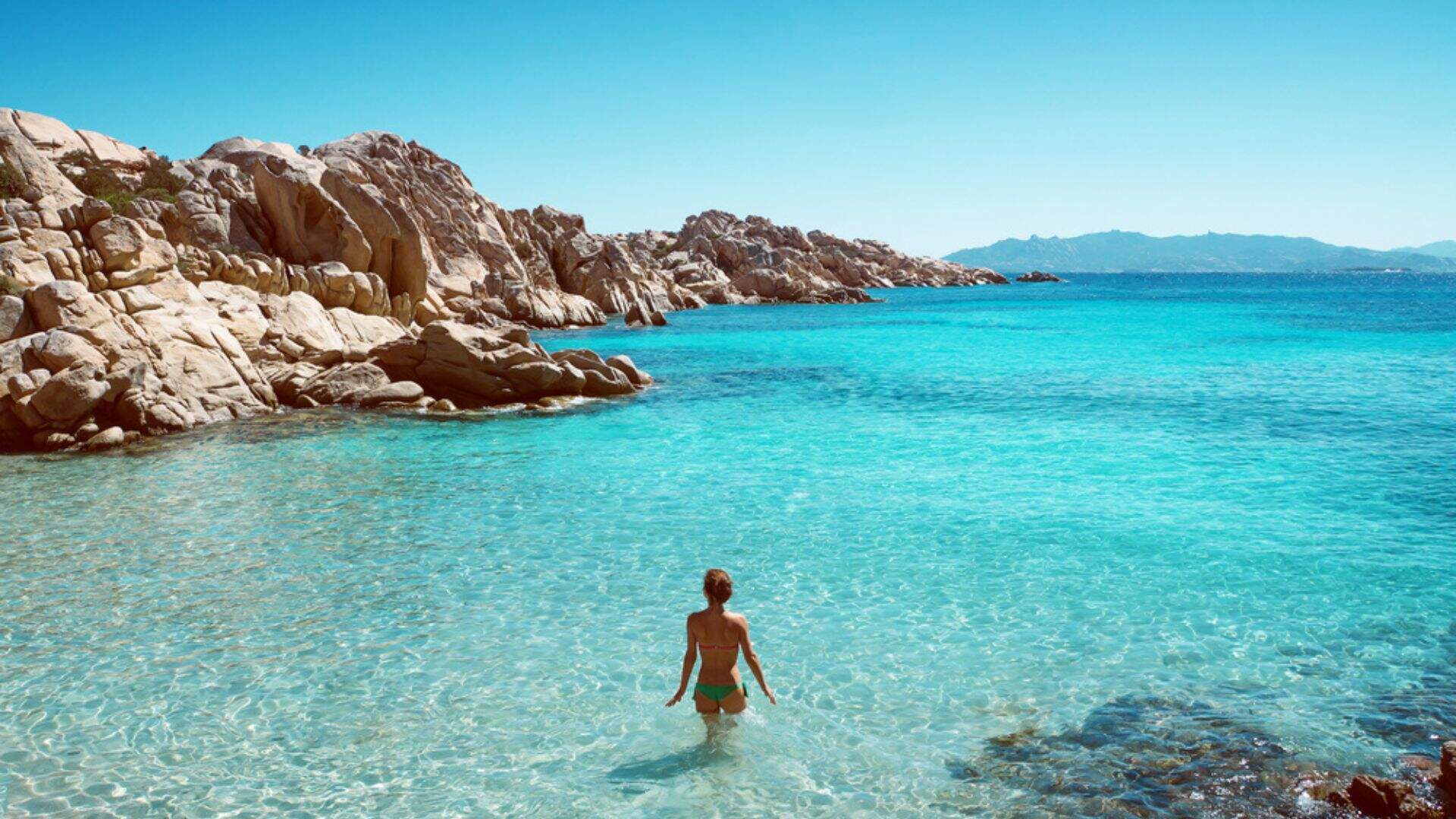 Vrouw in de helderblauwe zee van Italië