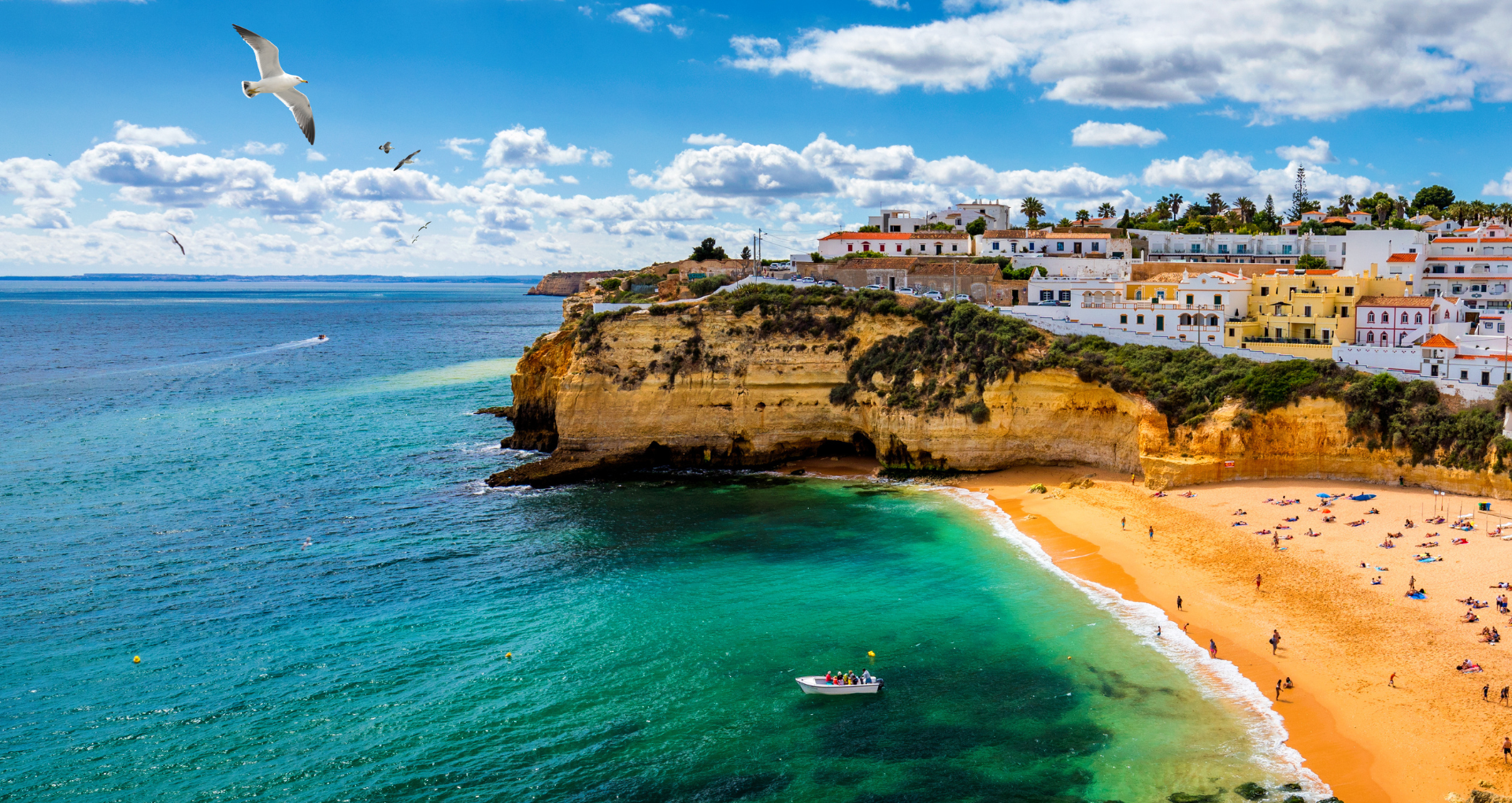 kustlijn met groenblauwe zee en gele rotspartijen van carvoeiro, algarve portugal