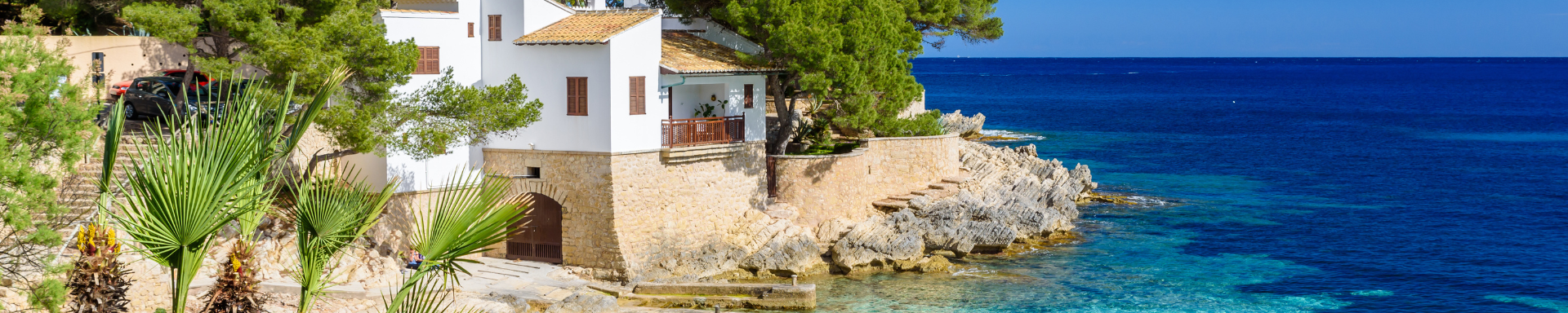 Huis op rotsen bij blauwe zee in Mallorca, Spanje