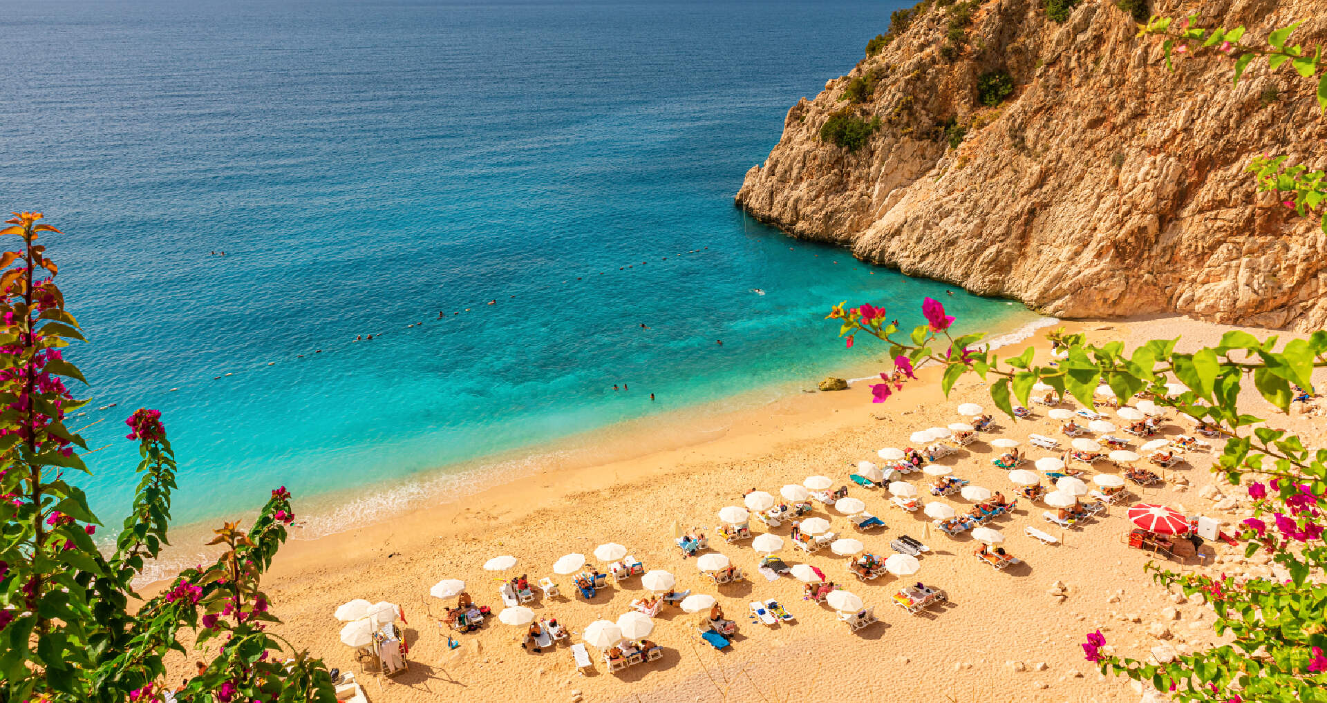 Zandstrand met ligbedden en bloemen in Antalya