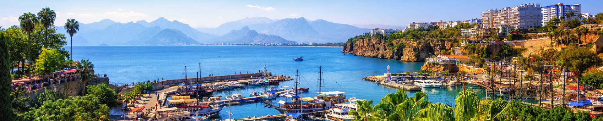uitzicht over havenstad in turkije aan baai met blauwe zee omringd door groen en hotels
