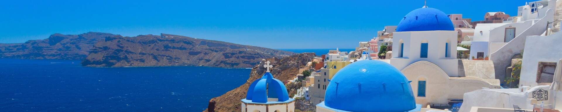 Griekse witte huisjes met blauwe daken, met uitzicht op de zee