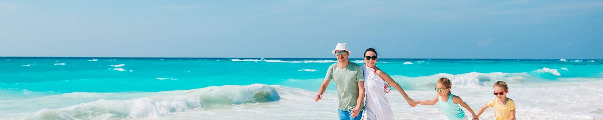Blije familie aan het wandelen bij de zee