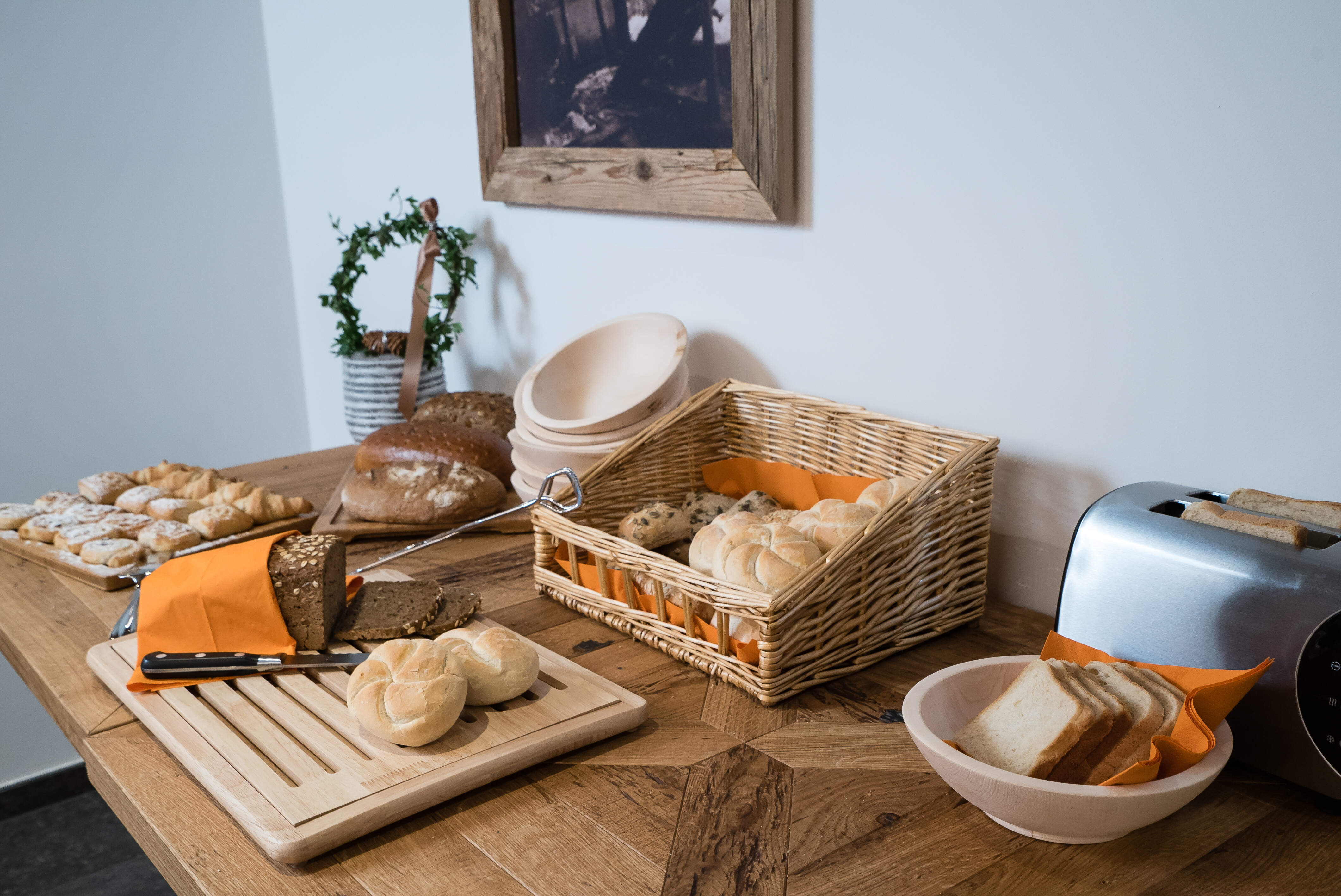 ontbijttafel met kaiserbroodjes op een snijplank in een catered chalet 