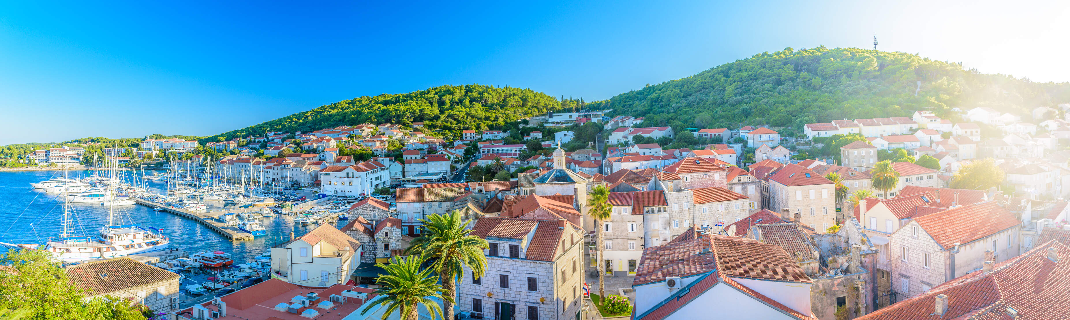 huisjes naast kustlijn van kroatie met haven en kleine bootjes