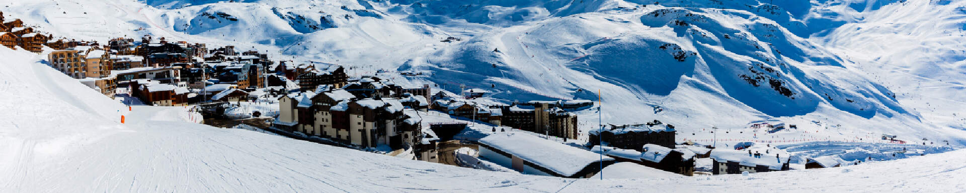 Huizen in een dorp onderaan een berg met een piste