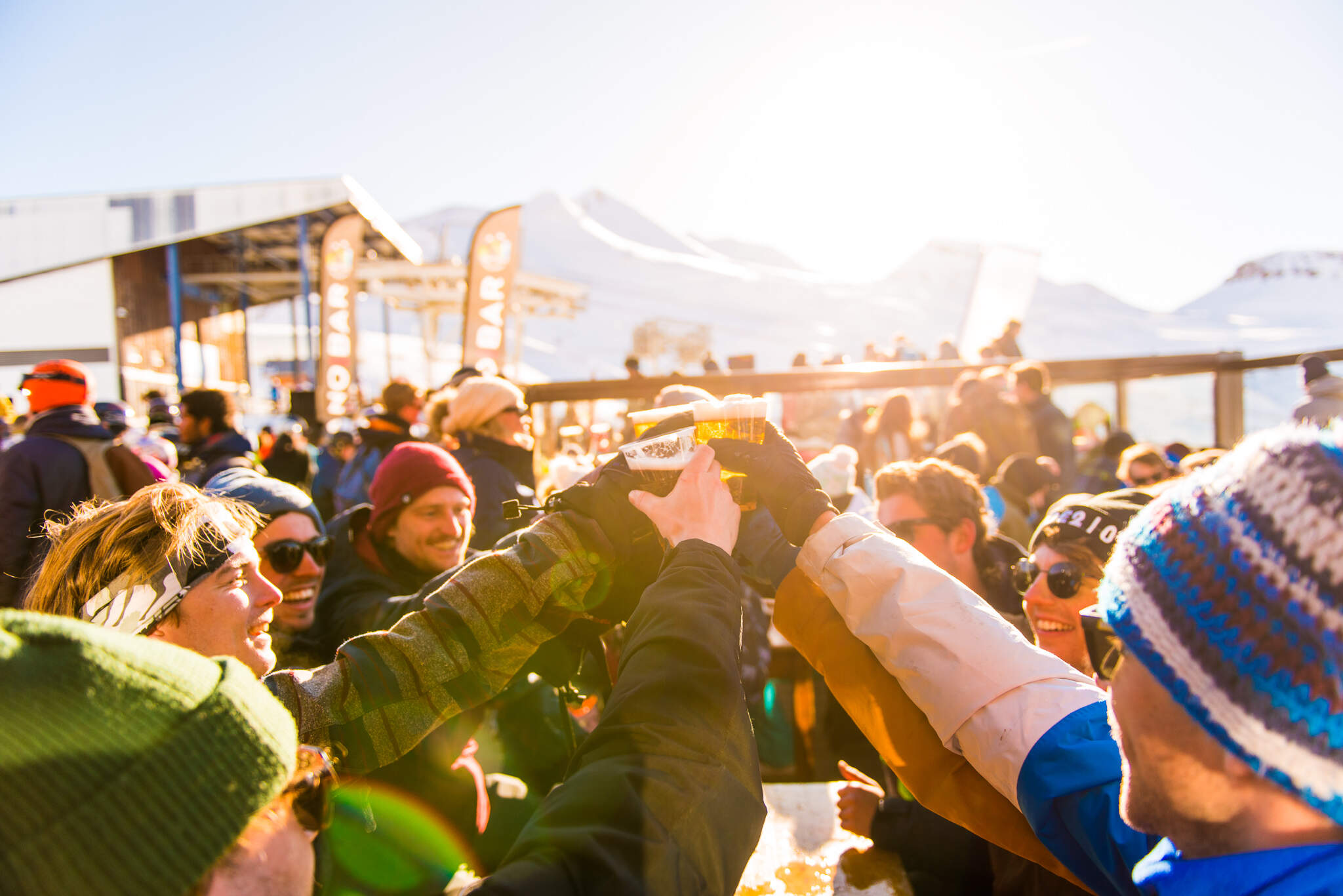 groep mensen in zonnig skigebied proosten tijdens apres ski