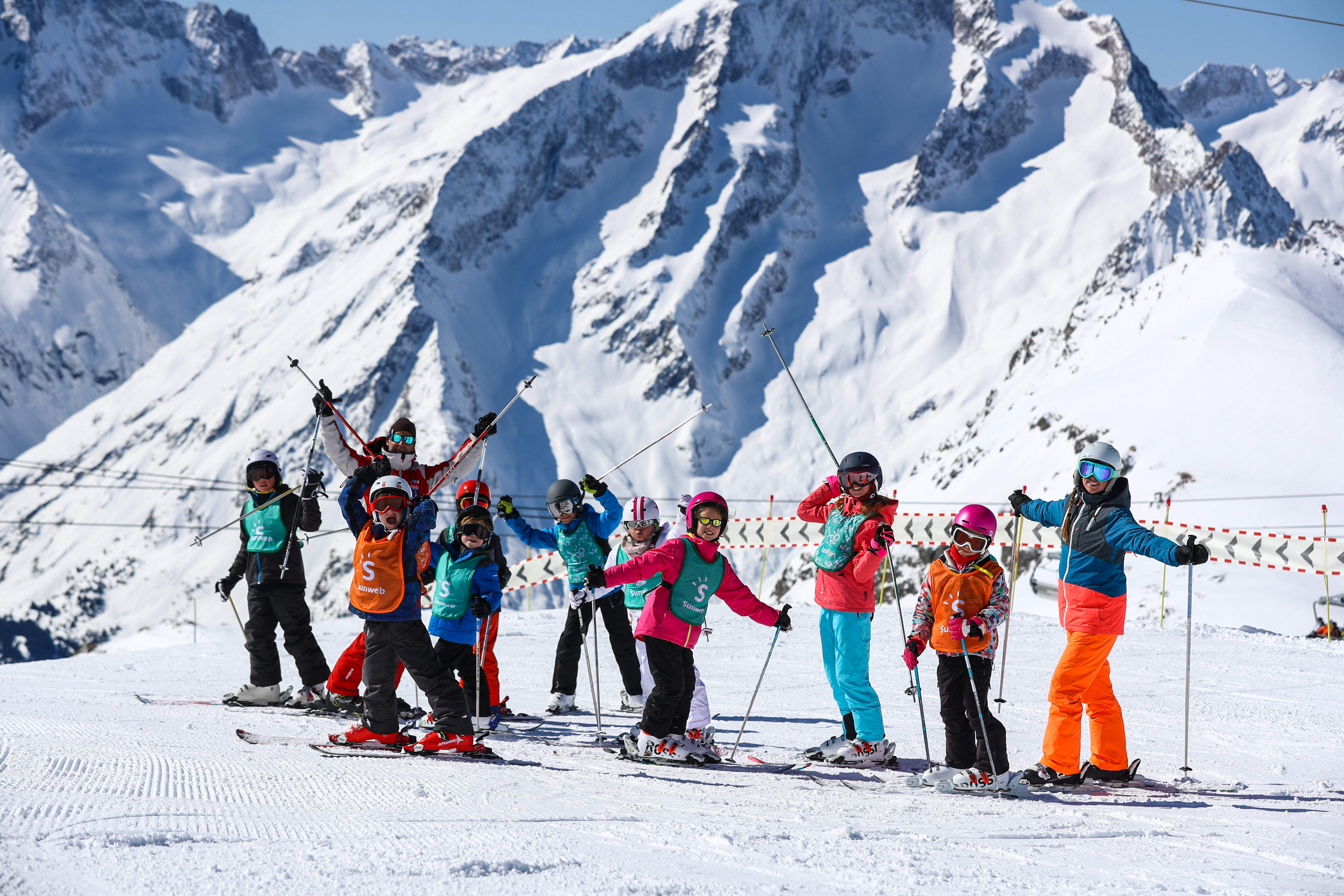 groep skiers op een skipiste die les krijgt
