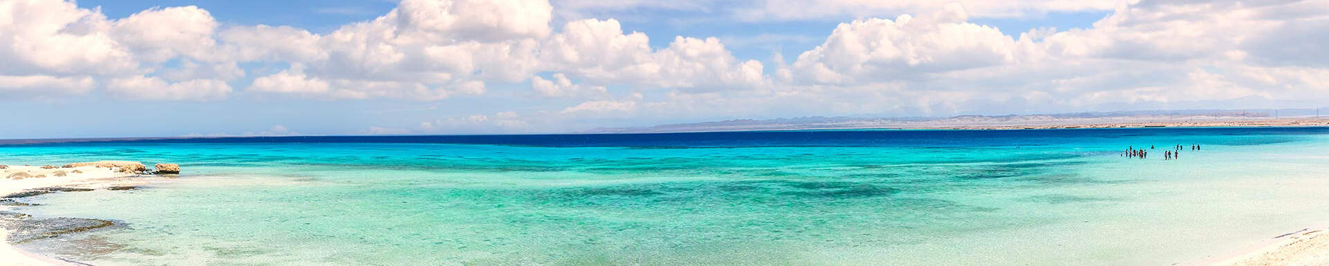 Een Egyptisch strand met een parelblauwe zee