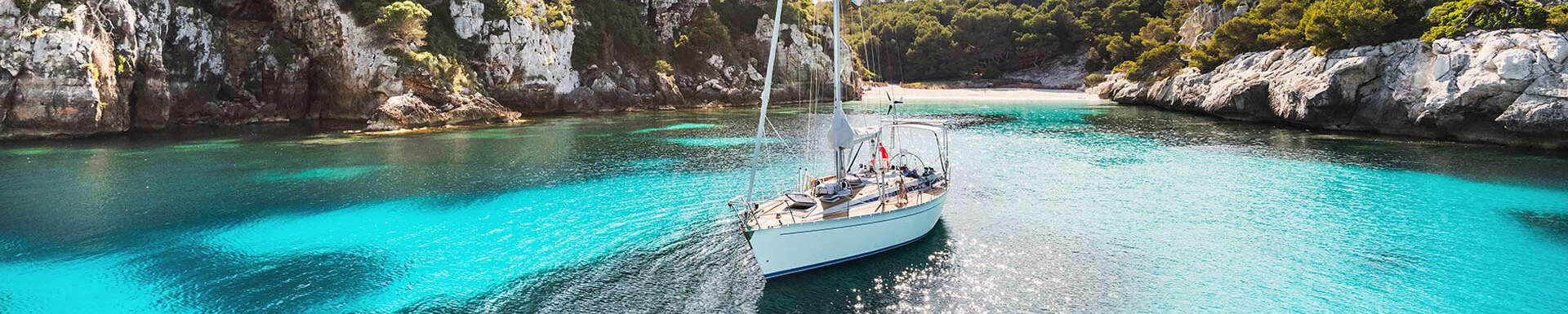 Zeilboot in de helderblauwe zee in een baai in ibiza, spanje